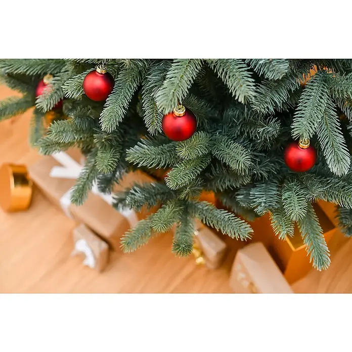 50 NRTH Künstlicher Weihnachtsbaum Vermont - Höhe: 240 cm, Grün, Standfuß - Nahaufnahme eines geschmückten Weihnachtsbaums mit roten Kugeln und darunter liegenden Geschenken, die festliche Stimmung vermitteln.