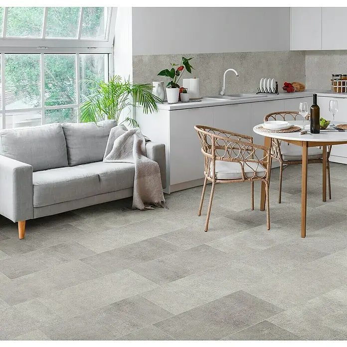 Feinsteinzeugfliese Rimini - 30,5 x 61 cm, Grigio, Matt - Helle Küche mit grauem Sofa, Esstisch und Stühlen auf einem modernen Steinfußboden.