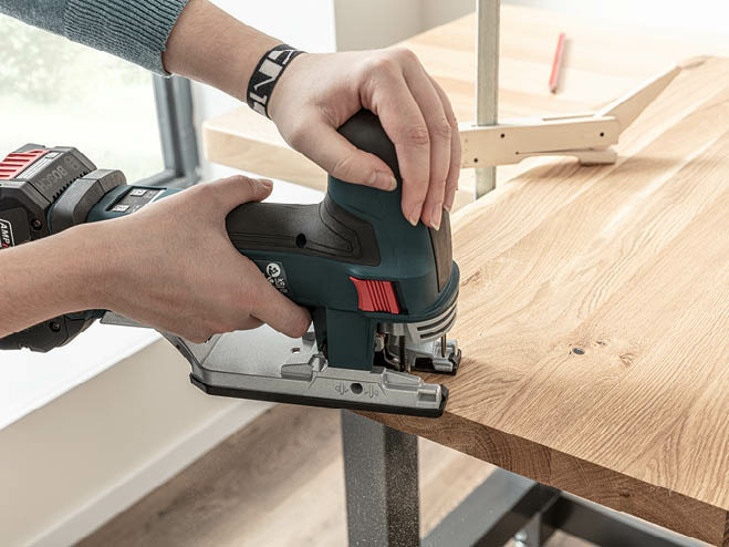 Eine Form wird aus dem Holzbrett mit einer Stichsäge ausgeschnitten