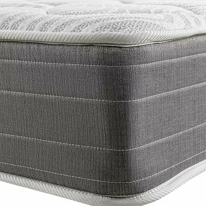 Espacio Descanso Colchón - Largo: 190 cm, Ancho: 90 cm, Altura: 26 cm, Muelles ensacados y Viscoelástica - Primer plano de un colchón gris con superficie acolchada y borde blanco. Sistema de descanso cómodo y de apoyo para un sueño reparador.