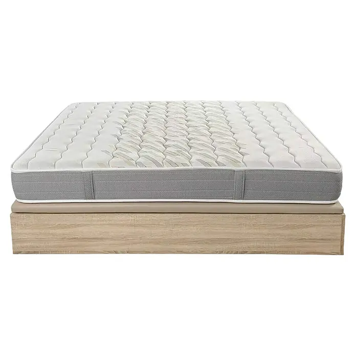 Espacio Descanso Canapé y colchón - L x An x Al: 190 x 90 x 56 cm, Natural, Abatible, Espuma HR y Viscoelástica - Primer plano de un colchón con un lado gris y la parte superior blanca, apoyado sobre una estructura de cama de madera.