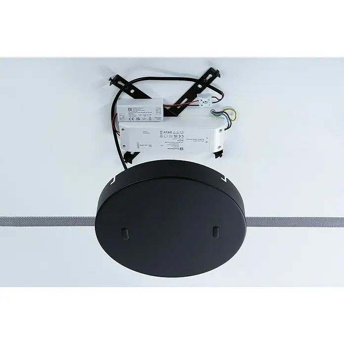 Paulmann ULine Dimmer - Weiß, 200 W - Nahaufnahme einer schwarzen Deckenleuchte mit Befestigungselementen und elektronischen Bauteilen an einer weißen Decke.