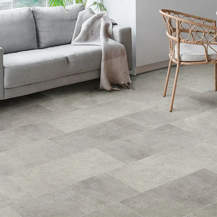 Feinsteinzeugfliese Rimini - 30,5 x 61 cm, Grigio, Matt - Einrichtung mit einem grauen Sofa, einem Rattansessel und einem Bodenbelag aus grauen Fliesen für ein modernes Wohnambiente.