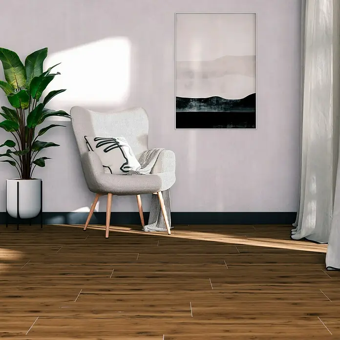 Feinsteinzeugfliese Essenza - 30 x 120 cm, Marrone, Matt - Wohnzimmer mit Holzboden, Sessel und Zimmerpflanze. Das Interieur ist hell und freundlich gestaltet.