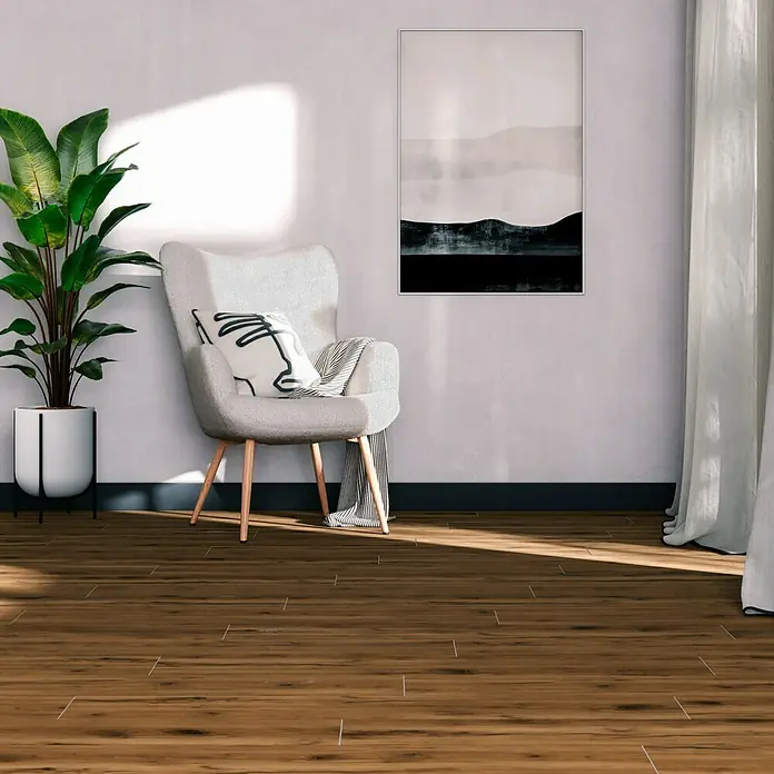 Feinsteinzeugfliese Essenza - 20 x 120 cm, Marrone, Matt - Elegantes Interieur mit Holzboden, einem bequemen Sessel und einer stilvollen Zimmerpflanze, die eine warme und einladende Atmosphäre schaffen.