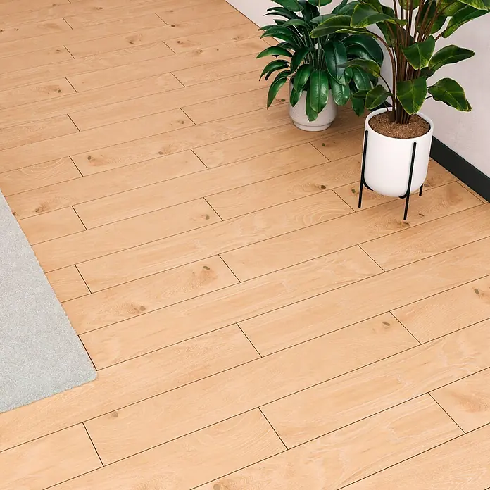 Atlas Concorde Solution Feinsteinzeugfliese Kortex Golden - 20 x 120 cm, Hellbraun, Matt - Ein helles Holzlaminat mit leichten Maserungen, ergänzt durch grüne Zimmerpflanzen in weißen Töpfen. Ideal für ein freundliches Ambiente.