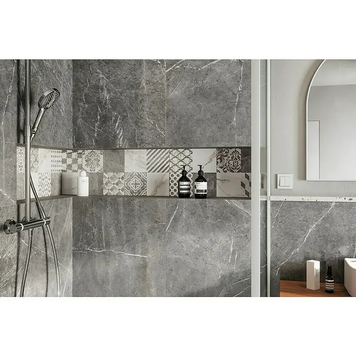 Atlas Concorde Solution Marble Vison Feinsteinzeugfliese Grigio Chiaro - 60 x 120 cm, Grau, Glänzend - Eine moderne Badezimmerecke mit grauen Marmorfliesen, einer Regendusche und einer Ablage mit Pflegeprodukten.