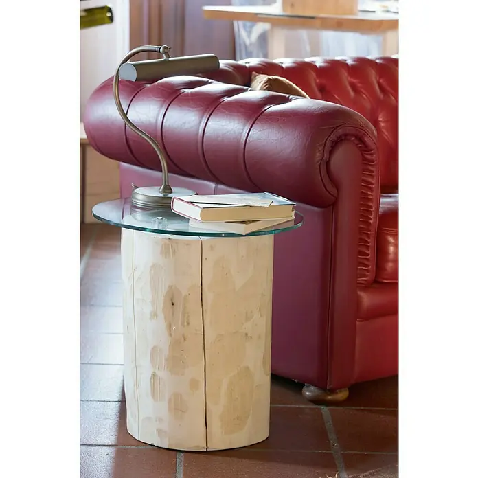 Bloque de madera maciza redondo 45 - Abeto, Ø x Al: 30 x 45 cm - Una moderna mesa auxiliar de madera con tapa de vidrio y una elegante lámpara, junto a un sofá de cuero rojo para un ambiente elegante.