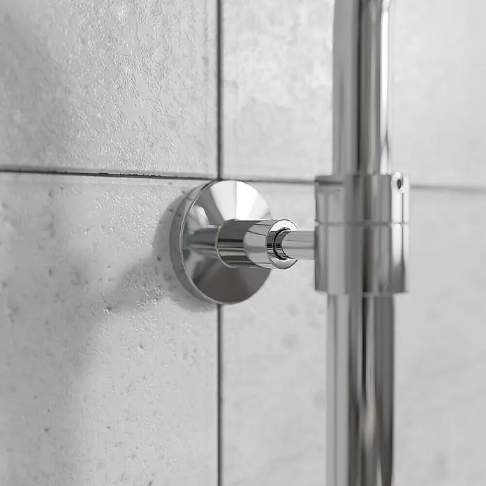Mixomat Duschsystem Orlando - Höhe: 118 cm, Chrom, Glänzend - Nahaufnahme eines glänzenden, verchromten Handtuchwärmers, der an einer gefliesten Wand befestigt ist, mit Fokus auf Details und Oberflächenbeschaffenheit.