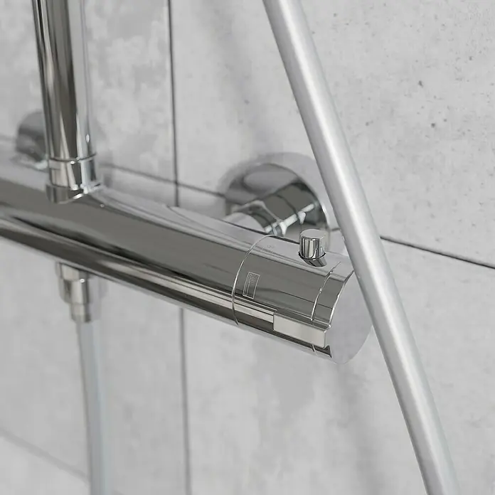 Mixomat Duschsystem Orlando - Höhe: 118 cm, Chrom, Glänzend - Nahaufnahme einer glänzenden Duscharmatur mit Temperaturregler und Sicherheitsknopf, montiert an einer gefliesten Wand.
