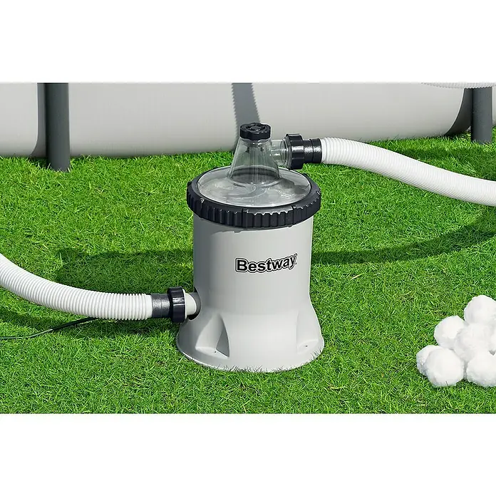 Bestway Filterpumpe - Ø x H: 27,2 x 42,1 cm, Filterleistung: 5.678 l/h - Nahaufnahme einer Bestway-Filterpumpe mit Schläuchen auf einer grünen Rasenfläche, ideal für die Poolpflege.
