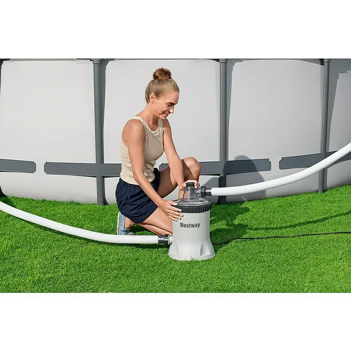 Bestway Filterpumpe - Ø x H: 27,2 x 42,1 cm, Filterleistung: 5.678 l/h - Frau installiert eine Bestway Filterpumpe für einen Pool, um das Wasser sauber zu halten und die Badesaison zu verlängern.