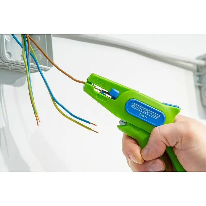 Weicon Kabelentmanteler Rundkabel-Stripper No. 13 Green Line - Biopolymer, Grün - Eine grüne Weicon Tools No. 5 Abisolierzange wird verwendet, um ein braunes Kabel freizulegen, das aus einer Verteilerdose kommt.