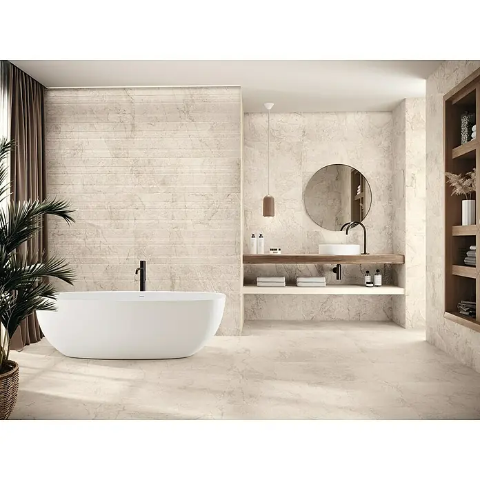Wandfliese Lorena - 40 x 120 cm, Bone, Matt - Elegantes Badezimmer mit freistehender Badewanne, Waschtisch mit rundem Spiegel und offenem Regal, das eine ruhige und luxuriöse Atmosphäre schafft.