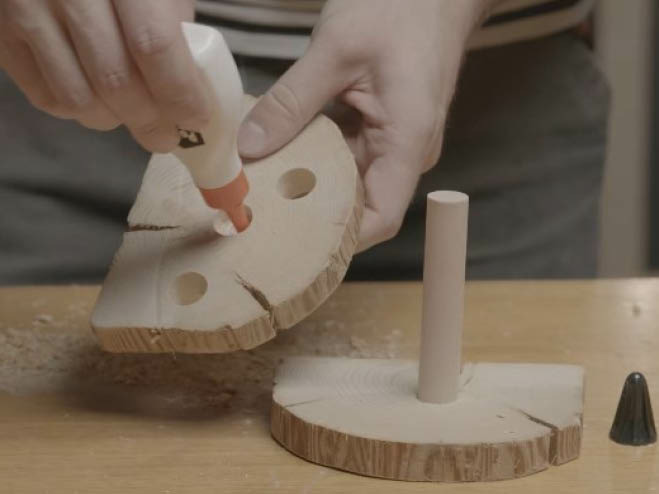 Mit Holzleim werden die zwei Baumscheiben mit dem Rundstab verbunden
