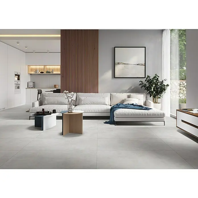 Feinsteinzeugfliese Diosa Light - 59,7 x 119,7 cm, Grey, Matt - Einladendes Wohnzimmer mit modularem Sofa, minimalistischen Tischen und stilvoller Dekoration für ein modernes Ambiente.