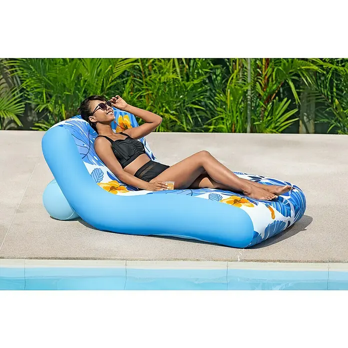 Bestway Luftmatratze Blissfull Drifter - Länge: 155 cm, Breite: 96 cm - Frau entspannt auf einer blauen, aufblasbaren Sonnenliege mit Blumenmuster am Pool.