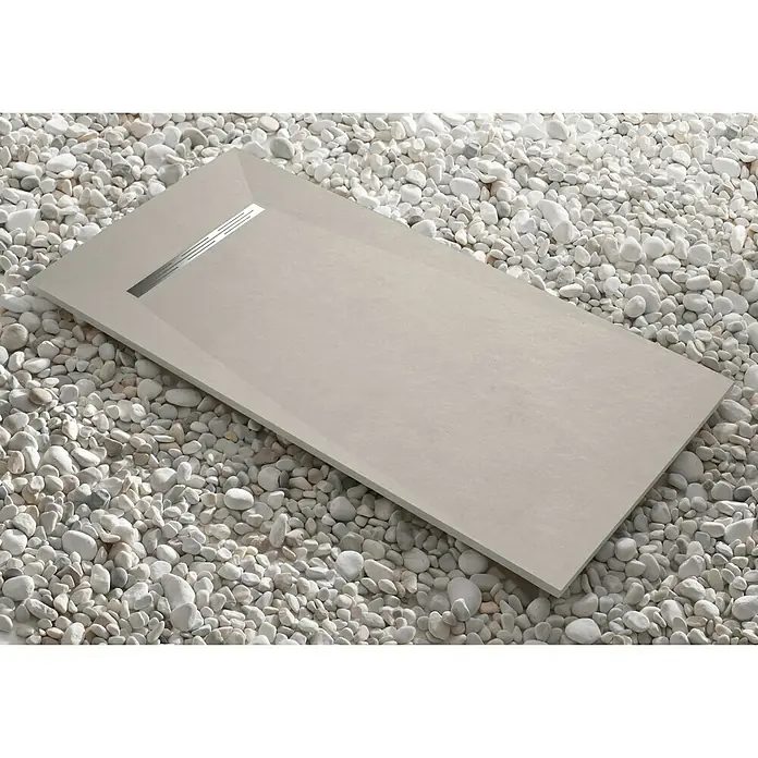 Camargue Plato de ducha Adriatic - L x An: 70 x 120 cm, Carga mineral, Cemento - Elegante plato de ducha rectangular en tono neutro, enclavado entre guijarros blancos decorativos, creando un ambiente de baño moderno.