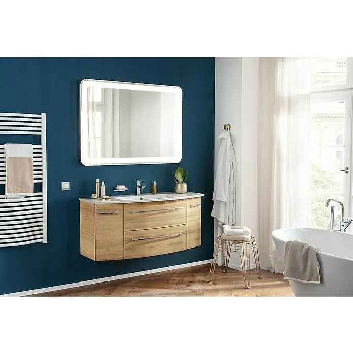 Camargue Badmöbel-Set - Berg Eiche, Matt, 120 cm, 3 -tlg., 17 W - Ein Badezimmer mit einem Waschtisch aus Holz, einem beleuchteten Spiegel und einem Handtuchwärmer an einer blauen Wand.