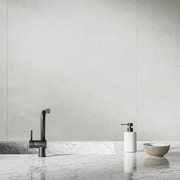 Feinsteinzeugfliese Cloudstone - 59,7 x 59,7 cm, Pearl, Matt - Elegantes Badezimmer-Interieur mit modernem, schwarzem Wasserhahn, stilvollem Seifenspender und einer dekorativen Schale auf einer Marmoroberfläche.
