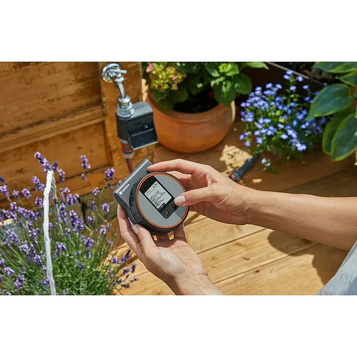 Gardena Bewässerungscomputer Flex - Bewässerungsdauer: 1 s - 99 min - Nahaufnahme des Gardena Bewässerungscomputers, der in den Händen gehalten und eingestellt wird. Bewässerungssteuerung für den Garten.
