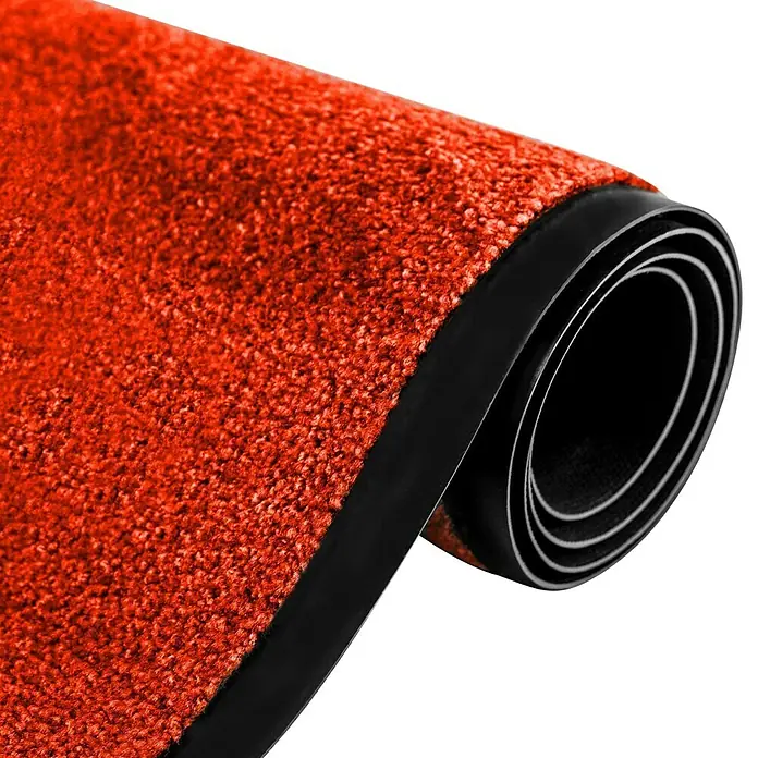 Fußmatte Rhine - Rot, 180 x 120 cm, 100 % Polyamid - Ein aufgerollter, orangeroter Teppich mit schwarzem Rand. Das Material scheint weich und einladend zu sein, ideal für den Eingangsbereich.