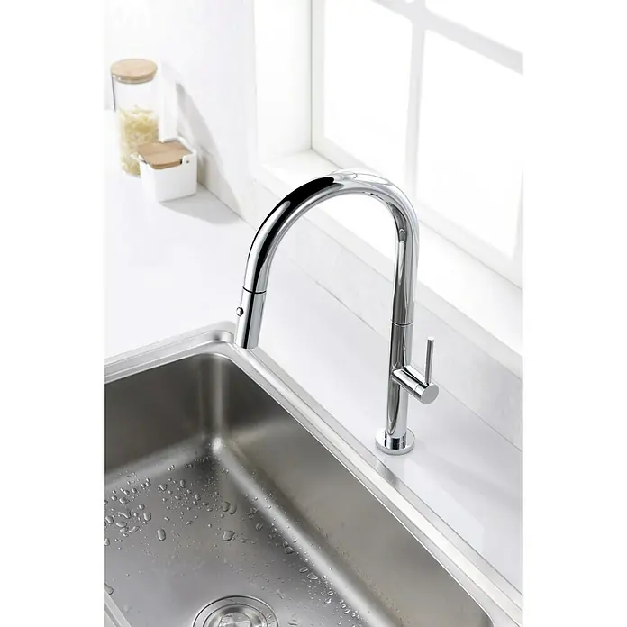 Imex Grifo de cocina extraíble Samoa - Cromo - Elegante grifo de cocina cromado con rociador extraíble y control de palanca única sobre un fregadero de acero inoxidable, con una ventana al fondo.