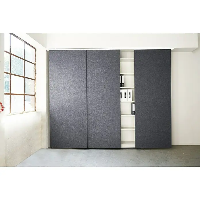 Schiene für Akustikpaneele - Weiß, 210 cm - 4-läufig - Grauer Filz-Schiebetürenschrank mit weißen Regalen und Aktenordnern in einem hellen Raum. Er bietet Stauraum und ist ein modernes Büromöbel.