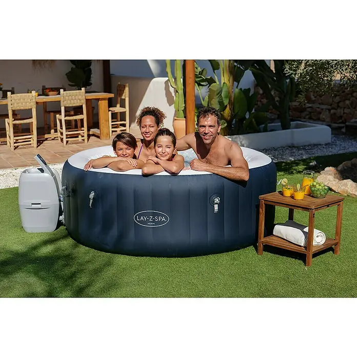 Bestway Lay-Z-Spa Mobil-Whirlpool Miami Air-Jet - Ø x H: 180 x 66 cm, Dunkelblau, 669 l - Eine Familie entspannt in einem Lay-Z-Spa Miami Whirlpool im Freien, neben einem Beistelltisch mit Getränken.