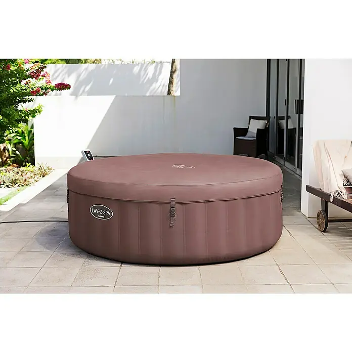Bestway Lay-Z-Spa Mobil-Whirlpool Hawai - Ø x H: 196 x 71 cm, Terrakotta, 916 l - Ein Lay-Z-Spa Whirlpool in einem Garten. Der Whirlpool ist abgedeckt und wirkt einladend für entspannende Stunden im Freien.