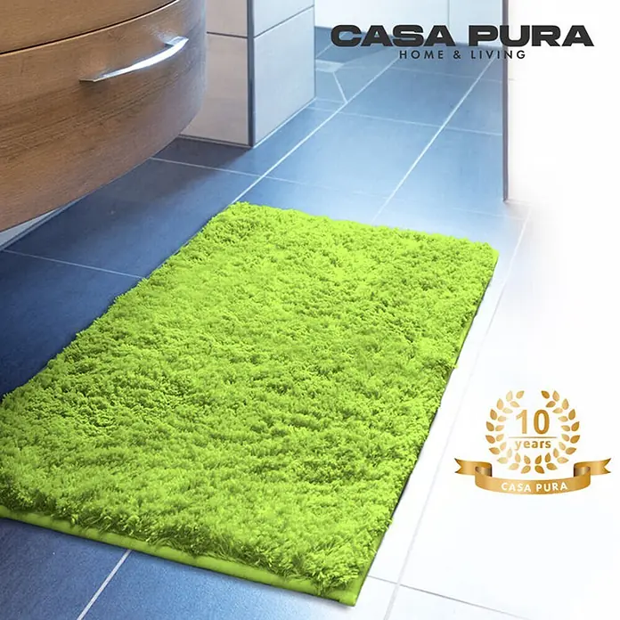 Floordirekt Badteppich Sky - 150 x 80 cm, Apfelgrün, 100% Polyester - Ein limettengrüner, rechteckiger Badteppich von Casa Pura liegt auf einem Badezimmerboden mit hellen Fliesen.