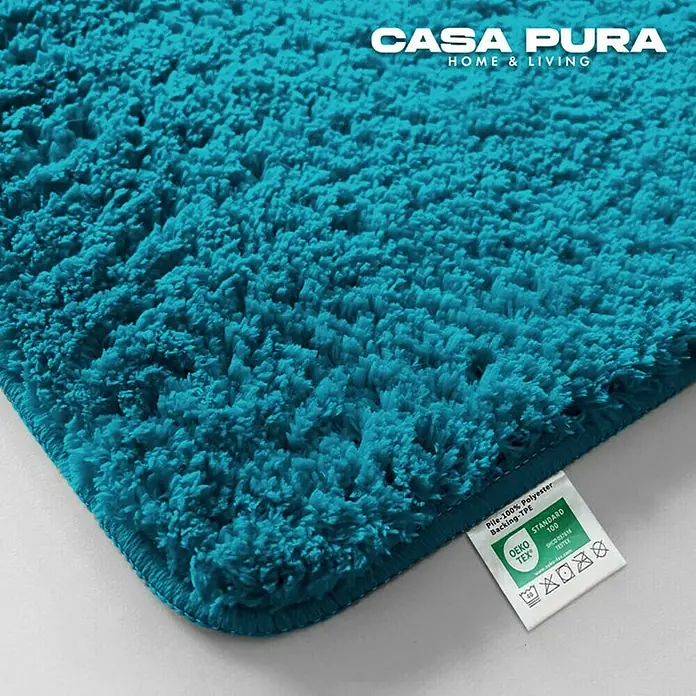 Floordirekt Badteppich Sky - 120 x 70 cm, Petrol, 100% Polyester - Nahaufnahme eines türkisfarbenen Casa Pura Teppichs mit weicher Textur und Produktsiegel für hohe Qualitätsstandards.