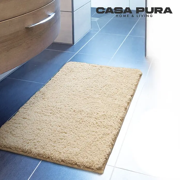 Floordirekt Badteppich Sky - 120 x 70 cm, Beige, 100% Polyester - Beiger Casa Pura Badteppich aus weichem Flor auf blau gefliestem Badezimmerboden, der Komfort und Sicherheit bietet.