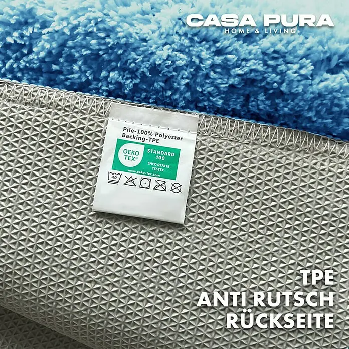 Floordirekt Badteppich Sky - 100 x 60 cm, Hellblau, 100% Polyester - Detailaufnahme einer blauen Casa Pura Badematte mit rutschfester TPE-Rückseite und Pflegeetikett.
