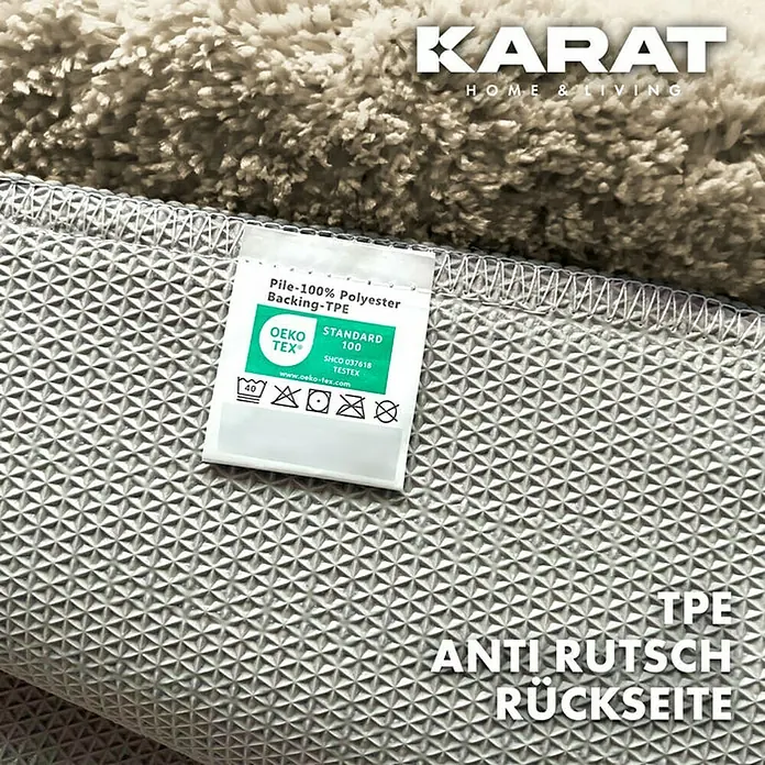 Floordirekt Badteppich Atlantis - 120 x 70 cm, Beige, 100% Polyester - Nahaufnahme der rutschfesten Unterseite eines KARAT HOME & LIVING Teppichs mit Pflegehinweisen, die auf Polyester hinweisen.