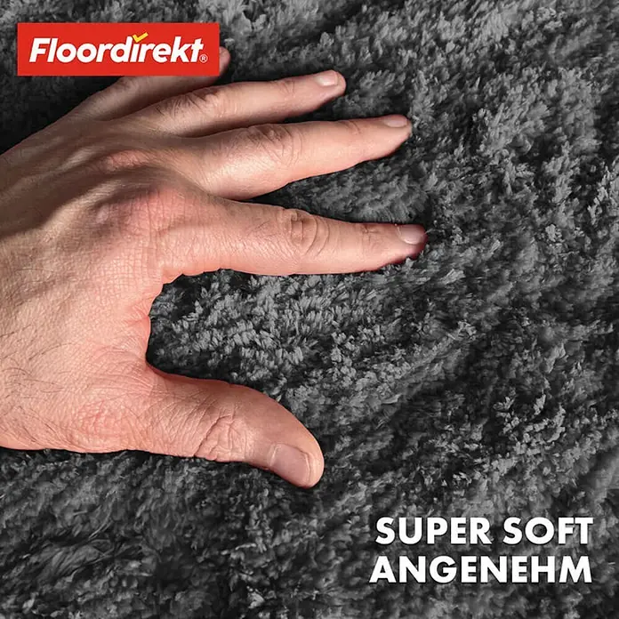Floordirekt Badteppich Sky - 120 x 120 cm, Dunkelgrau, 100% Polyester - Detailaufnahme eines grauen, superweichen Teppichs mit Hand, die die Textur betont. Zertifiziert mit OEKO-TEX Standard 100.