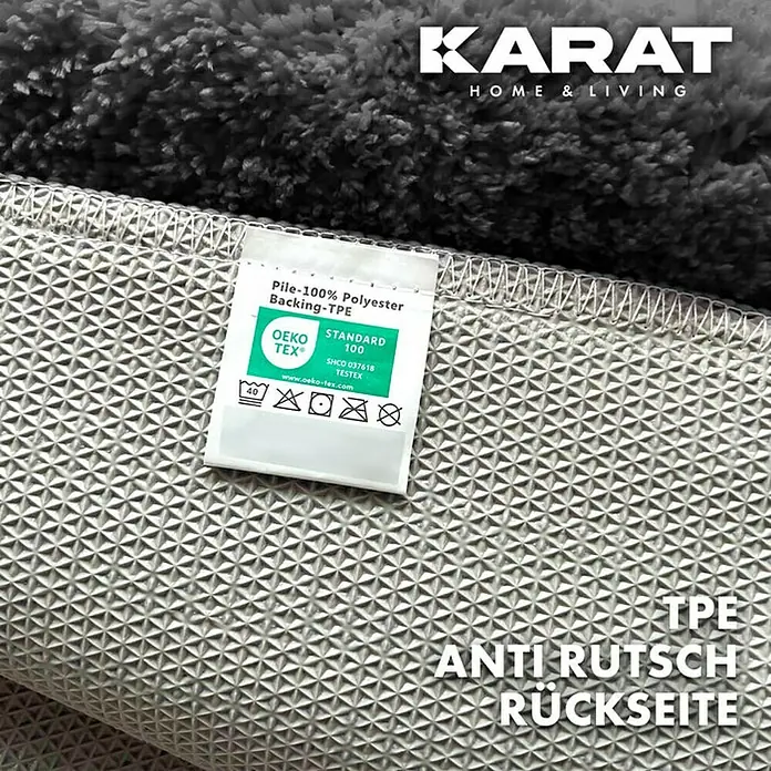 Floordirekt Badteppich Atlantis - 100 x 60 cm, Dunkelgrau, 100% Polyester - Detailaufnahme eines KARAT Teppichs, der die rutschfeste TPE-Rückseite und das OEKO-TEX®-Zertifikat zeigt.