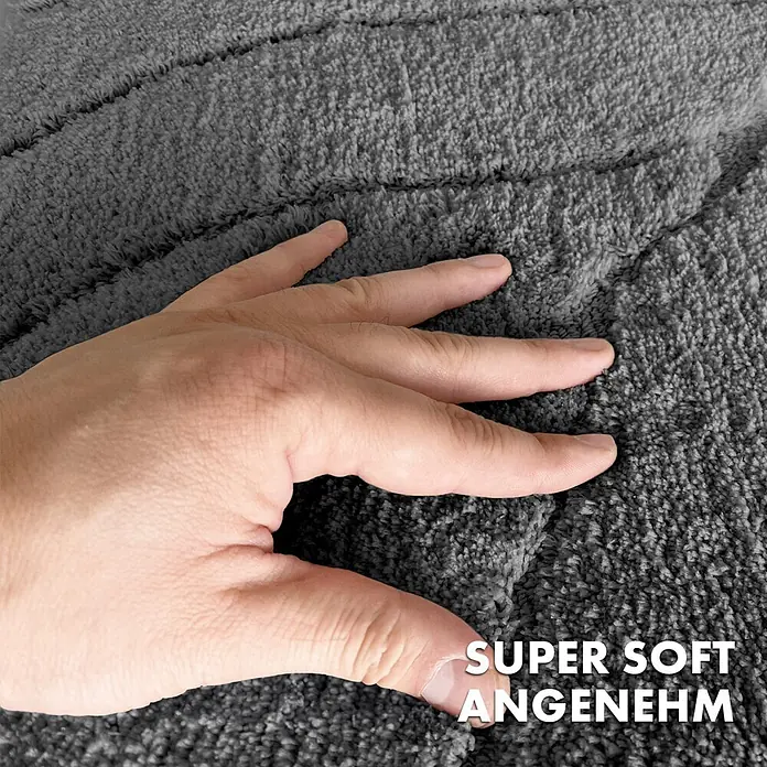 Floordirekt Badteppich Maris - 60 x 40 cm, Dunkelgrau, 100% Polyester - Nahaufnahme einer Hand, die ein graues, superweiches Bademattenprodukt mit OEKO-TEX-Zertifizierung berührt.