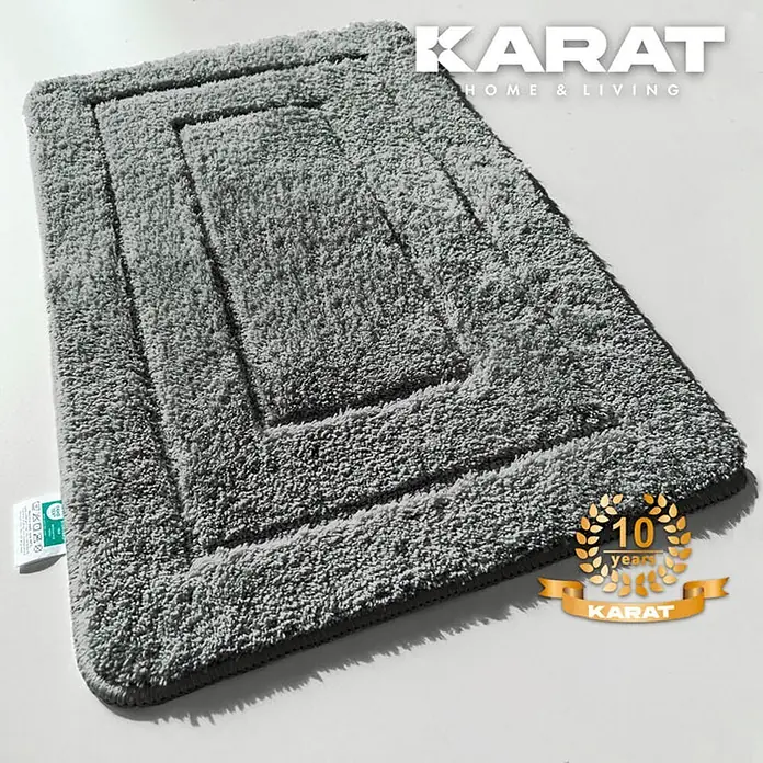 Floordirekt Badteppich Atlantis - 100 x 60 cm, Dunkelgrau, 100% Polyester - Ein grauer, rechteckiger Badteppich mit einem gestuften Design und dem "KARAT"-Logo, der Komfort und Stil vereint.