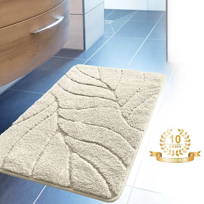 Floordirekt Badteppich Maris - 120 x 60 cm, Ivory, 100% Polyester - Ein beiger Badteppich mit Blattmuster liegt auf blauen Fliesen im Badezimmer.