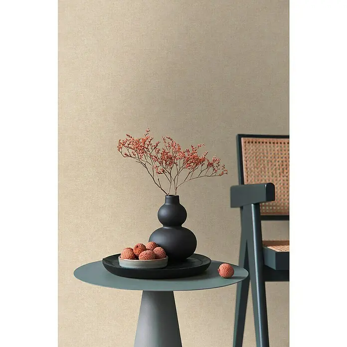 A.S. Création Metropolitan Stories Hot Spots Vliestapete - Beige, Uni, 10,05 x 0,53 m - Stilleben mit einer schwarzen Vase, einer Schale mit Litschis auf einem Tisch und einem Stuhl im Hintergrund.