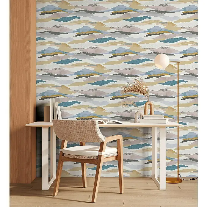 A.S. Création Pintwalls 2 Vliestapete Wolken-Wellen - Blau-Rosa-Beige, Grafisch, 10,05 x 0,53 m - Büroszene mit Schreibtisch, Stuhl und Stehlampe vor einer gemusterten Tapete mit abstraktem Wolkenmuster in verschiedenen Farben.