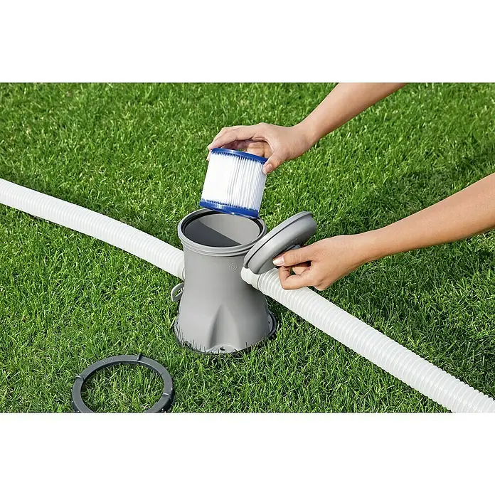 Bestway Filterkartusche - Filterleistung: 1.029 l/h - Ein grauer Poolfilter mit einer Person, die eine Filterpatrone einsetzt, umgeben von einem weißen Schlauch auf einem grünen Rasen.