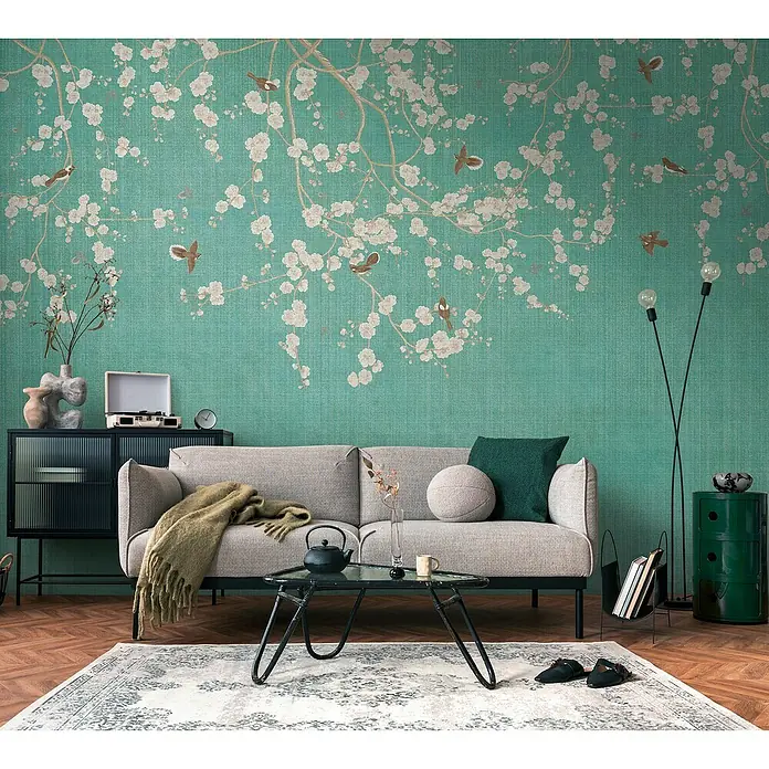 A.S. Création The Wall 3 Fototapete Blumenranken - B x H: 371 x 280 cm, Vlies - Wohnzimmer mit grauem Sofa, Couchtisch und grüner Akzentwand mit floralem Muster für eine gemütliche Atmosphäre.