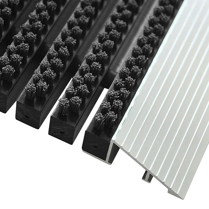 Fußmatte Profi Brush - Schwarz, 90 x 60 cm, 100 % Nylon - Detailaufnahme einer Eingangsmatte mit Bürstenprofilen und Aluminiumleisten. Ideal für den Eingangsbereich, um Schmutz effektiv abzufangen.