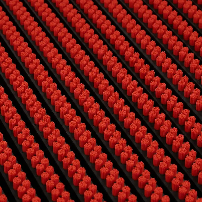 Fußmatte Power Brush - Rot, 60 x 40 cm, 100 % Nylon - Detaillierte Aufnahme einer roten, gestreiften Fußmatte mit schwarzen Rillen. Das Produkt fängt Schmutz zuverlässig auf.
