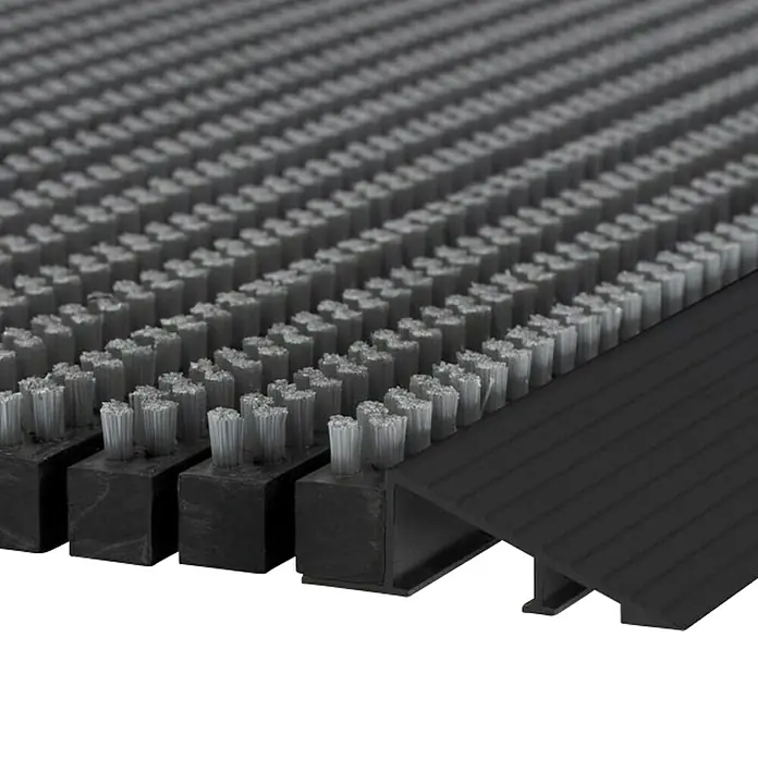 Fußmatte Power Brush - Grau, 60 x 40 cm, 100 % Nylon - Detailaufnahme einer schwarzen Fußmatte mit Bürsten und schwarzem Rampenprofil. Robust und funktional für den Eingangsbereich.