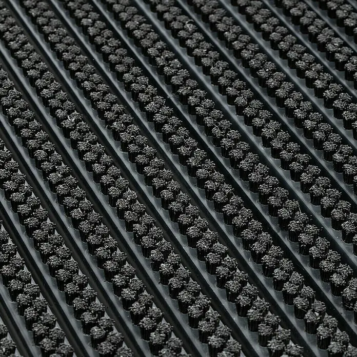 Fußmatte Power Brush - Schwarz, 60 x 40 cm, 100 % Nylon - Detailaufnahme einer schwarzen Fußmatte mit Noppenstruktur und Rillen. Ideal für den Eingangsbereich, um Schmutz abzufangen.