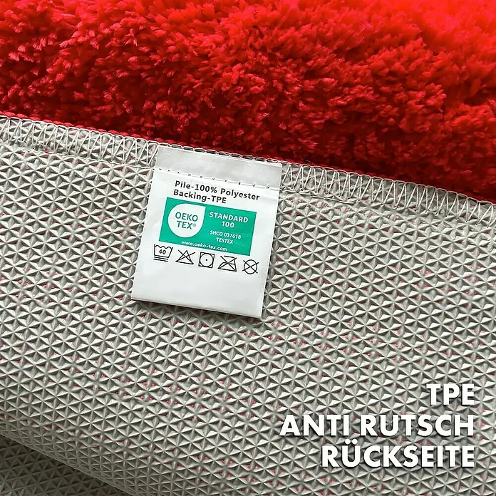 Floordirekt Badteppich Maris - 120 x 60 cm, Rot, 100% Polyester - Detailaufnahme eines roten Teppichs mit Fokus auf die rutschfeste TPE-Rückseite und das OEKO-TEX® Zertifikat für Schadstofffreiheit.