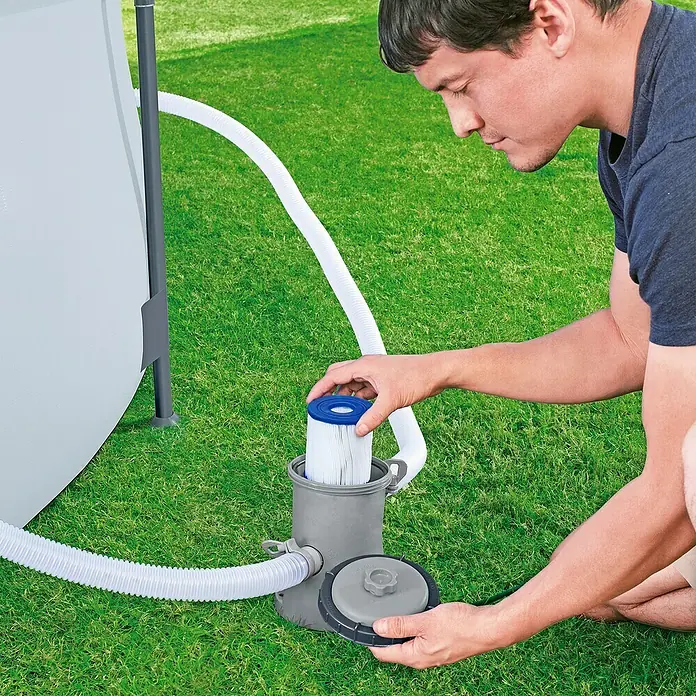 Bestway Filterkartusche - Filterleistung: 1.029 l/h - Ein Mann installiert eine Filterpumpe für einen Pool, um das Wasser sauber zu halten. Die Pumpe ist mit Schläuchen verbunden.